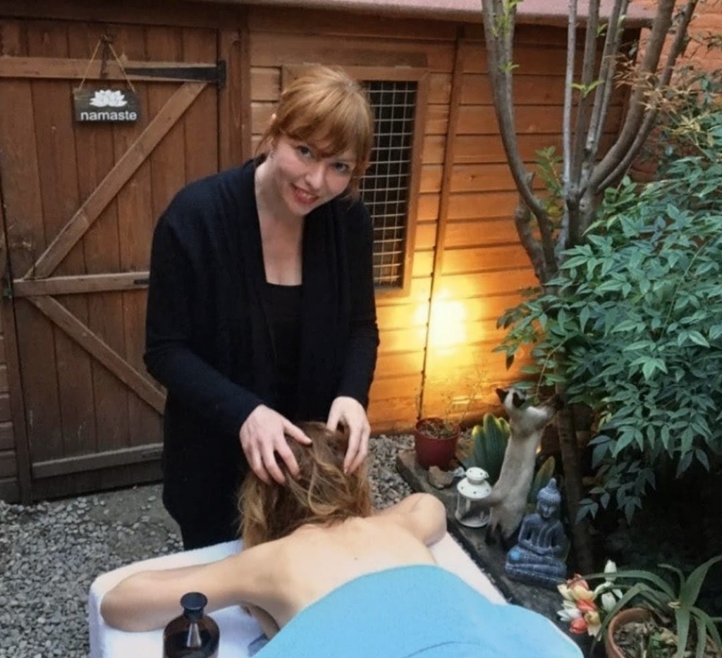 Mireia fent un massatge cap a una clienta en un espai exterior natural